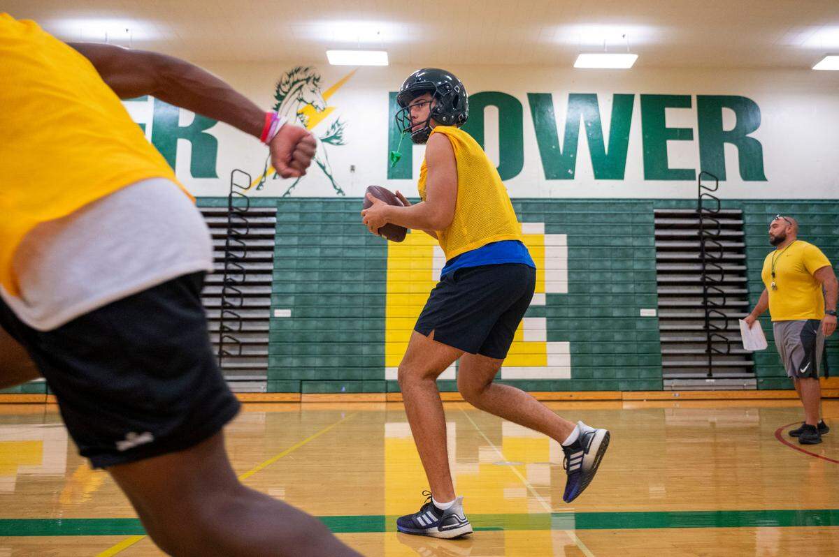 Kentridge quarterback Dorian Thomas shuffles back after taking a snap while working on team offensive drills during practice inside the school’s gym on Wednesday, Sept. 21, 2022, in Kent, Wash. Although Thomas quarterbacks the Chargers, we has committed to Oregon State where he will play tight end.