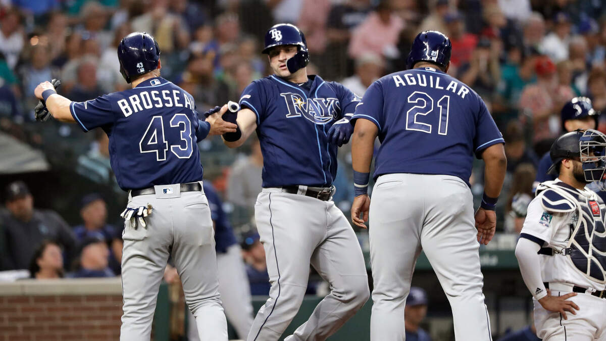 Tampa Bay Rays’ Mike Zunino, center, is congratulated at home on his three-run home run by Michael Brosseau (43) and Jesus Aguilar (21) as Seattle Mariners catcher Omar Narvaez waits for the next batter during the fifth inning of a baseball game Saturday, Aug. 10, 2019, in Seattle.