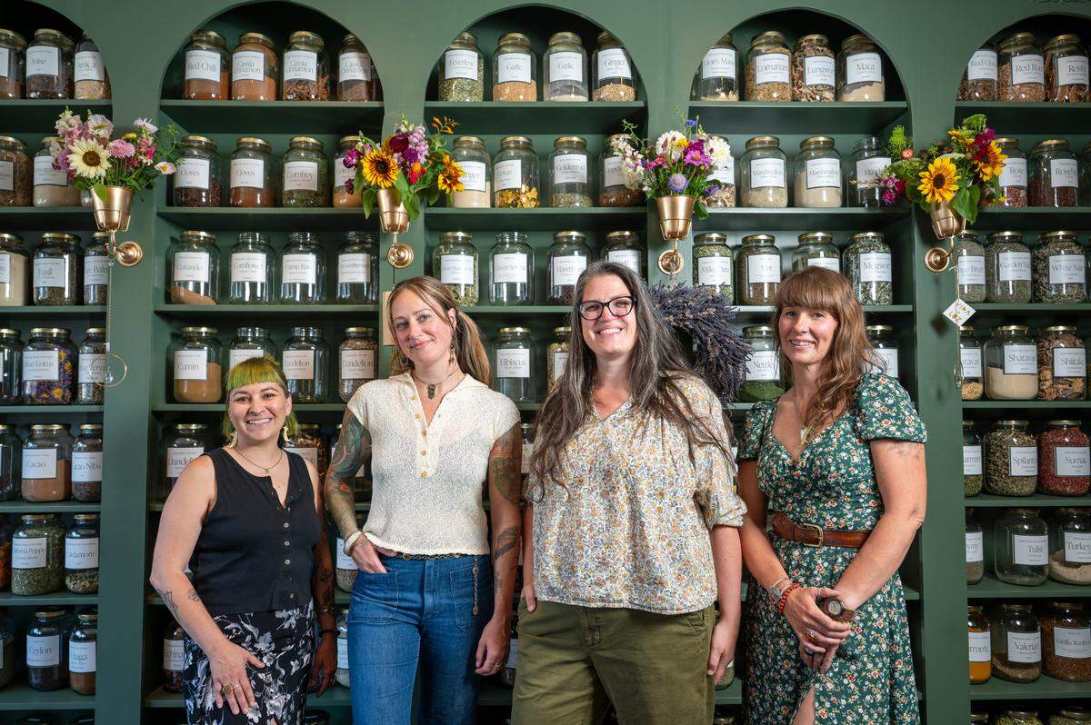 Team members at Hawthorn & Honey, made up of former and current students of founder Sara Butters’, stand for a portrait on Thursday, July 17, 2025, at the apothecary’s space in the Proctor neighborhood of Tacoma. From left are: Lisa Wood, shop manager, Rachele Piety, a vintage reseller located in the shop, Butters, and Celia Sharp, a team member at the shop.
