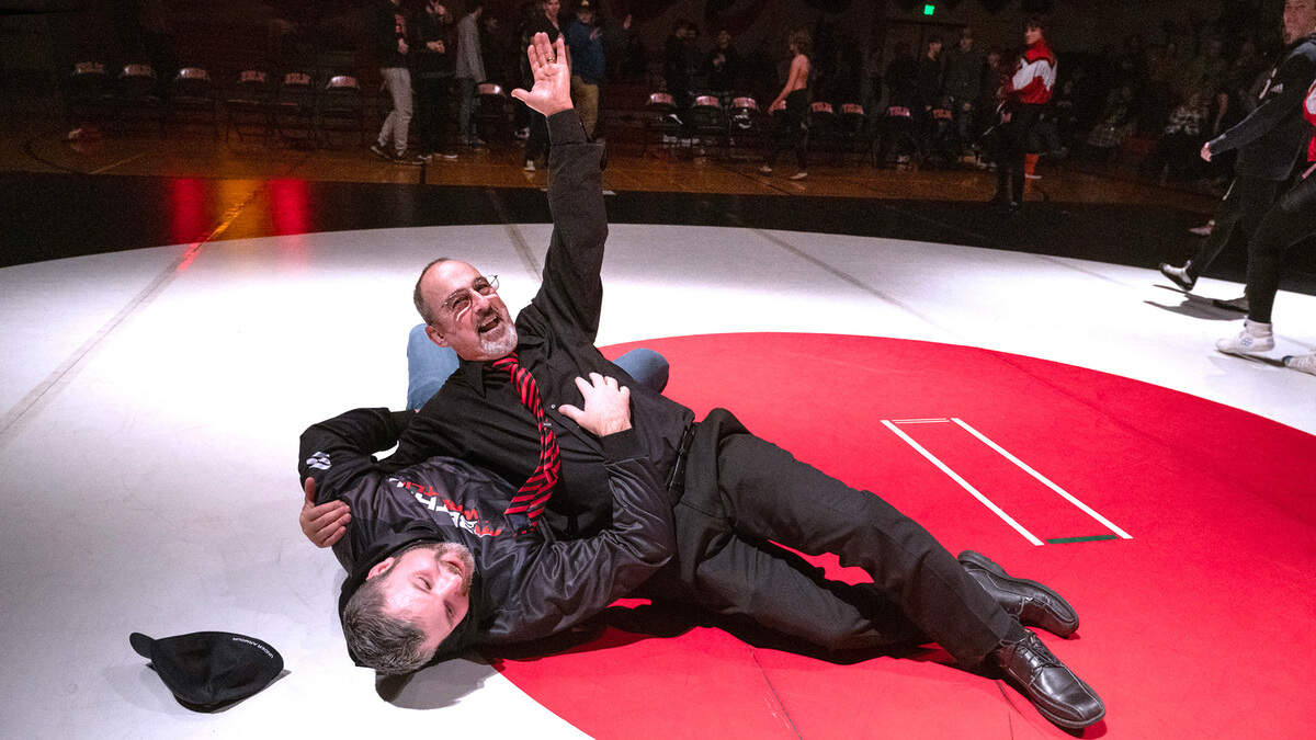 Yelm High wrestling coach Gaylord Strand gives a wave after playfully throwing Bethel head coach - and 2001 Yelm High graduate - Matt Lininger following Strand’s final home match. Strand has coached continuously at Yelm High School for 50 years. He was honored in a celebration following Tuesday night’s wrestling dual meet against the Bethel Bisons at Yelm High School in Yelm, Washington, on Jan. 23, 2024.