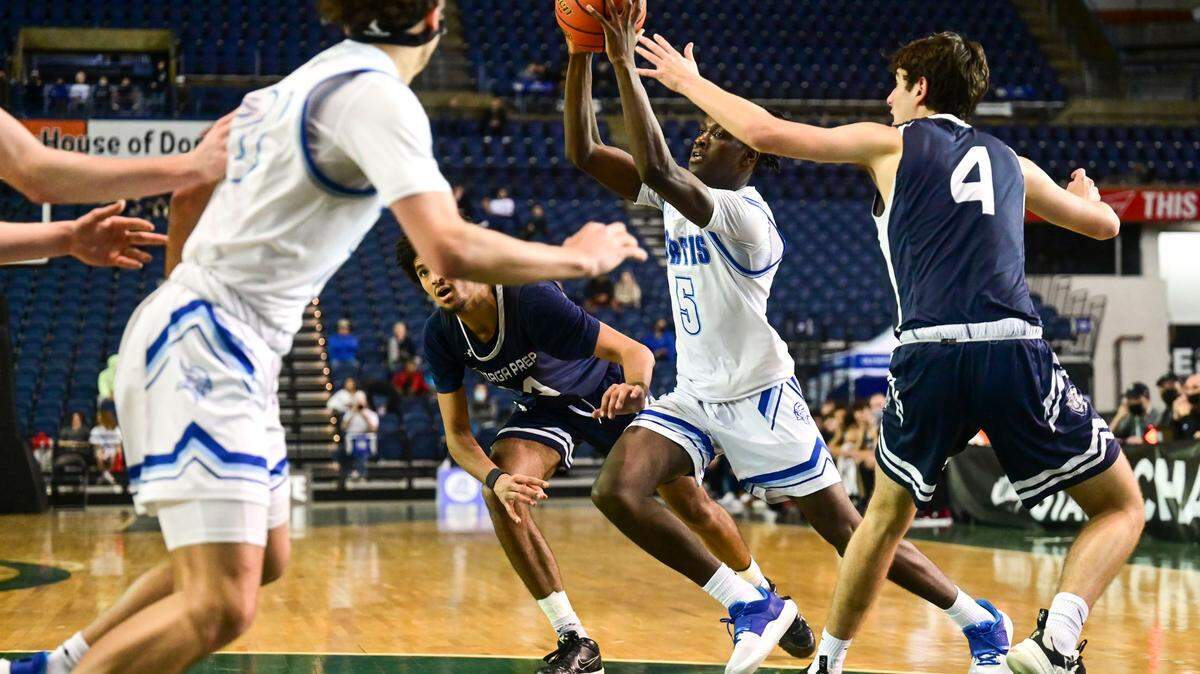 Curtis guard Zoom Diallo (5) looks to drive to the basket as he slices between by Gonzaga Prep forward Jayden Stevens (14) and forward Owen Jackson (4) during third quarter of a Class 4A quarterfinal state tournament game on Thursday, March 3, 2022, at the Tacoma Dome, in Tacoma, Wash.
