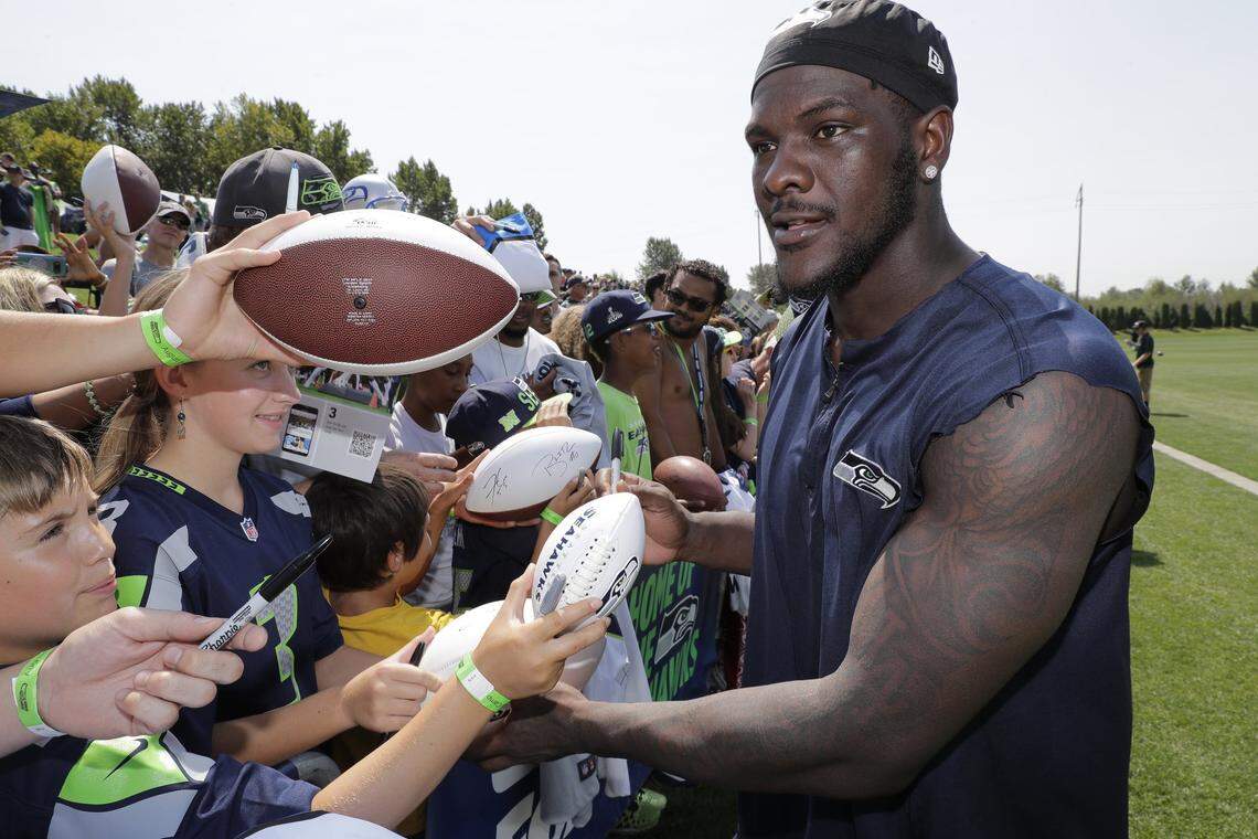 FILE - In this Aug. 6, 2018, file photo, Seattle Seahawks defensive end Frank Clark signs autographs following NFL football training camp, in Renton, Wash. The Kansas City Chiefs have agreed to acquire defensive end Frank Clark from the Seattle Seahawks in exchange for a first-round draft pick this year and a second-round pick in 2020. Almost immediately after word leaked of the trade on Tuesday, April 23, 2019, Clark and the Chiefs worked quickly to reach agreement on a five-year contract worth up to $105 million, according to a person with knowledge of the deal. The person spoke to The Associated Press on the condition of anonymity because the deal had not been announced by either team and was still pending a physical.(AP Photo/Ted S. Warren, File)
