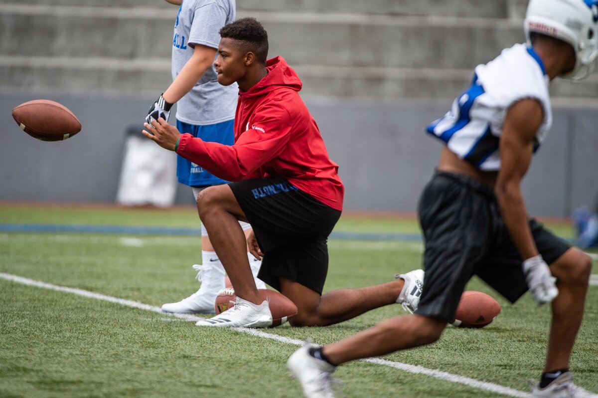 Wide receiver Xavier Mason, center, helps with passing drills during Stadium High School football practice at Stadium High School in Tacoma, Wash., on Thursday, Aug. 16, 2018. .
