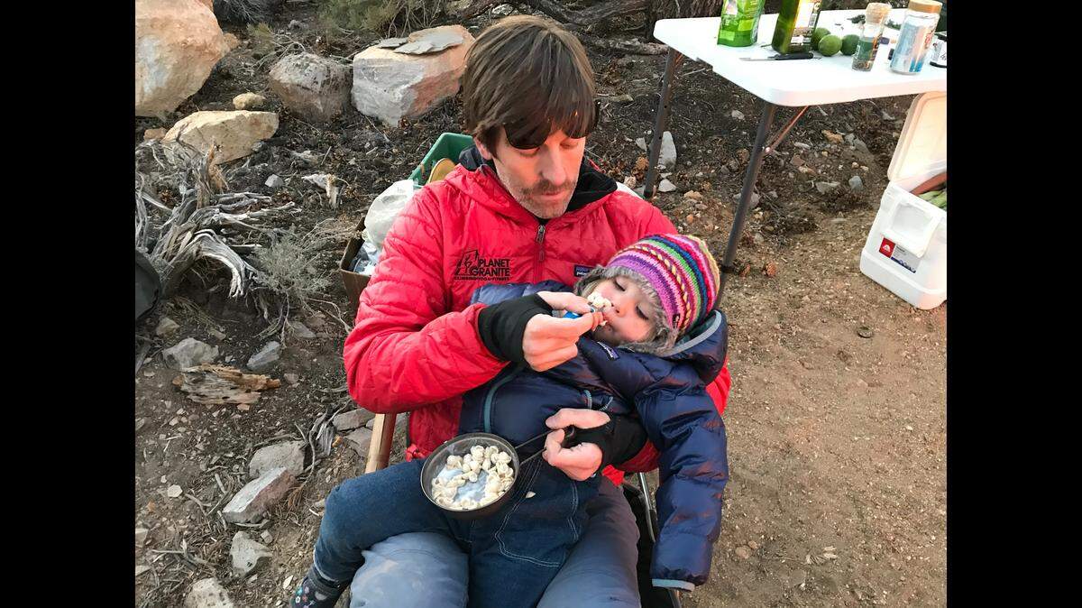 Gavin Feek feeding campfire mac and cheese to his daughter Willa in California’s White Mountains. 