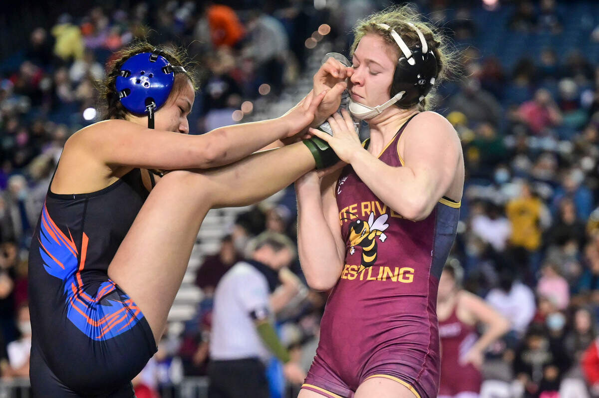 White River junior wrestler Shelby Moore gets a hold of the right leg of Graham-Kapowsin’s Shelby-R Enos-Cressy during the first round of their 130-pound girls quarterfinal match at Mat Classic XXXIII on Friday, Feb. 18, 2022, in Tacoma, Wash.