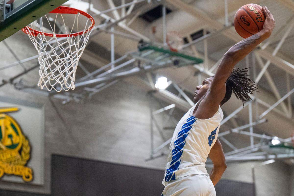 Federal Way forward Vaughn Weems (0) winds up to dunk the ball on a fast break in the second quarter of a Class 4A state tournament regional game against Gonzaga Prep on Friday, Feb. 24, 2023, at Auburn High School in Auburn, Wash.
