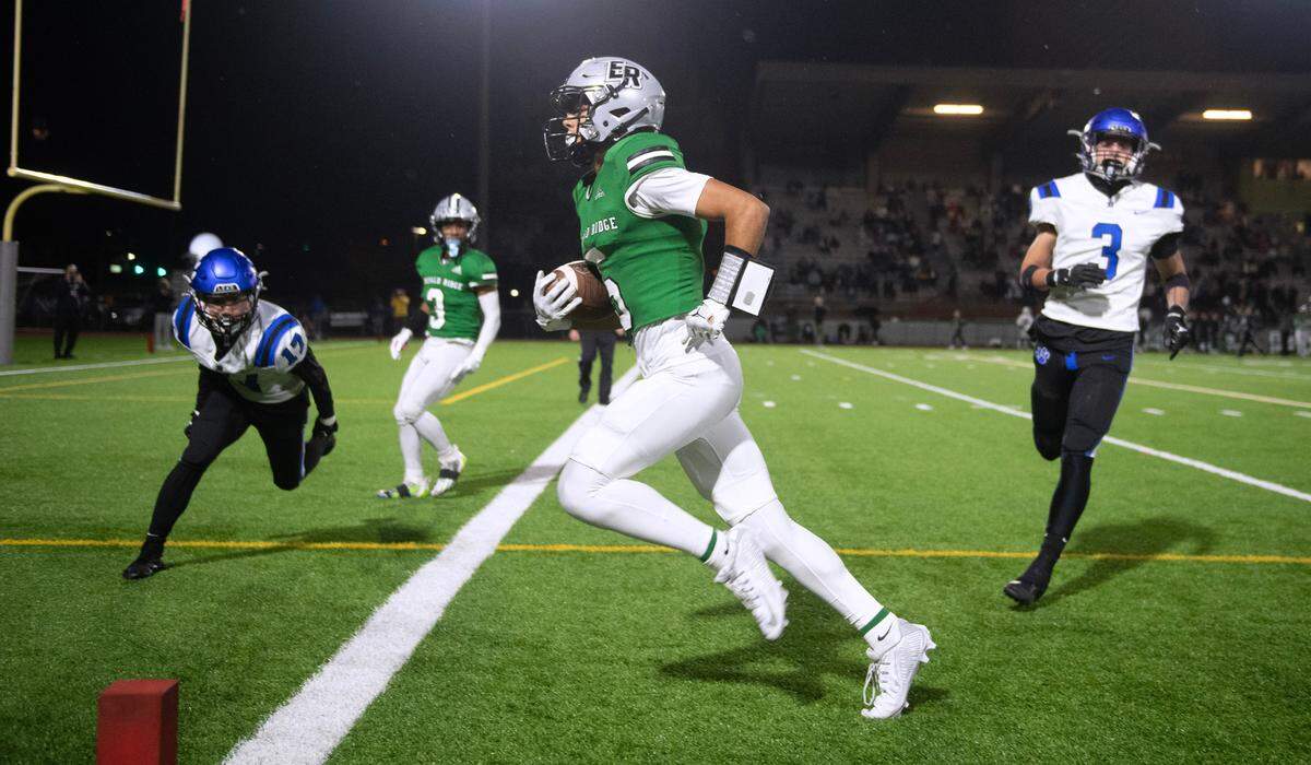 Emerald Ridge wide receiver Tony Harste cruises into the end zone for a touchdown in front of Bothell defenders Mason Kim (left) and Tyson Hoke during Friday night’s 4A district football game at Sparks Stadium in Puyallup, Washington, on Nov. 3, 2023. Emerald Ridge won the game, 50-36.
