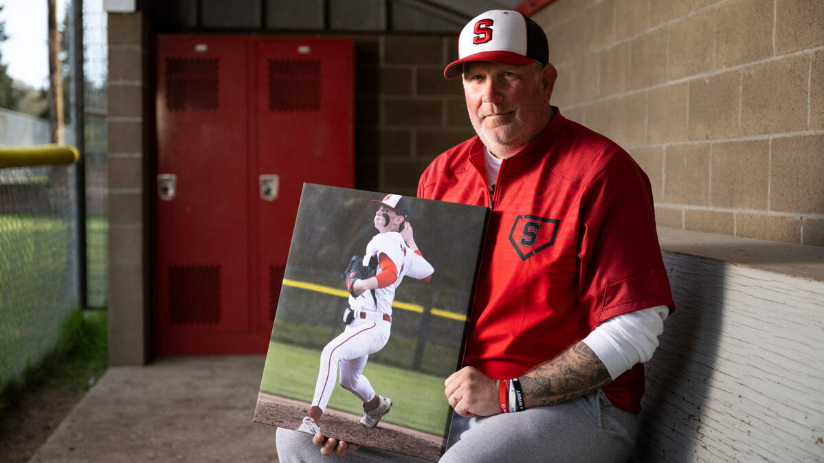 Steilacoom head baseball coach Corey Widman holds a photo of his son Reese Widman, who he lost to suicide last winter, at Steilacoom High School, on Monday, April 15, 2024, in Steilacoom, Wash.