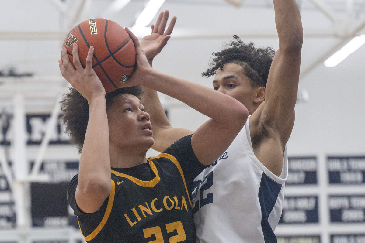 Lincoln Abes sophomore Justus Holt (22) looks up at the net while being guarded by Bellarmine Lions junior Ronnie Wiggins (22) on Wednesday, Jan. 28, 2026, in Tacoma.