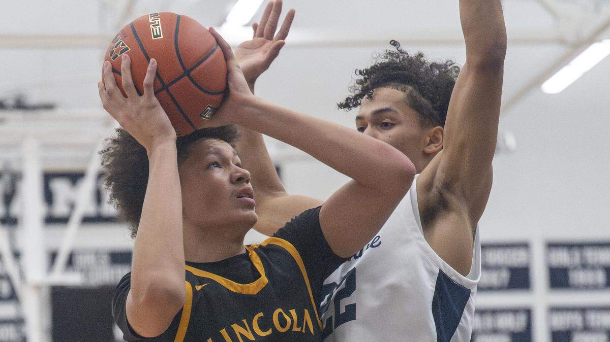 Lincoln Abes sophomore Justus Holt (22) looks up at the net while being guarded by Bellarmine Lions junior Ronnie Wiggins (22) on Wednesday, Jan. 28, 2026, in Tacoma, Wash.