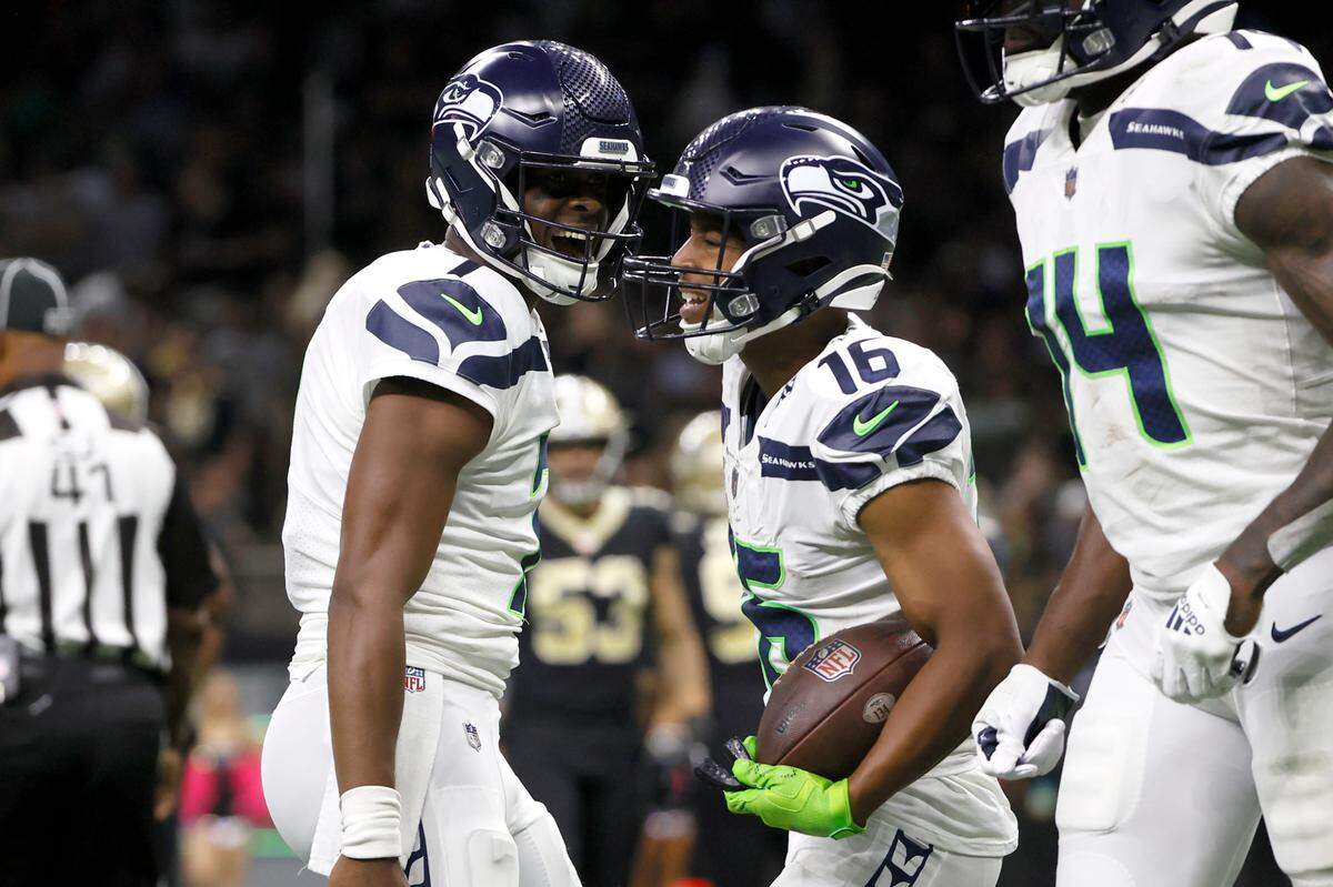 Seattle Seahawks quarterback Geno Smith, left, celebrate his touchdown pass to wide receiver Tyler Lockett during an NFL football game against the New Orleans Saints in New Orleans, Sunday, Oct. 9, 2022. (AP Photo/Derick Hingle)