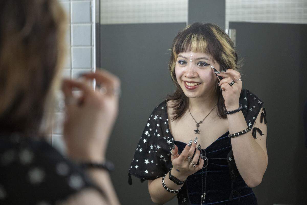 Elena Angeles places stars near her eyes while touching up makeup for the Oasis Youth Center’s Queer Prom on Saturday, April 18, 2026, at Pacific Lutheran University in Tacoma.