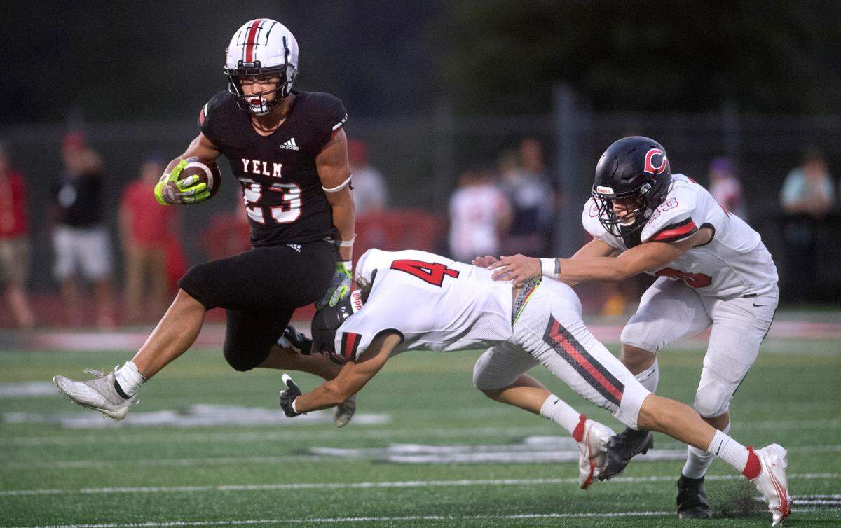 Yelm running back Brayden Platt leaps to elude Camas defensive back Jared Williams (4) and linebacker Nikko Speer during Friday night’s season-opening football game at Yelm High School in Yelm, Washington on Friday, Sept. 2, 2022.
