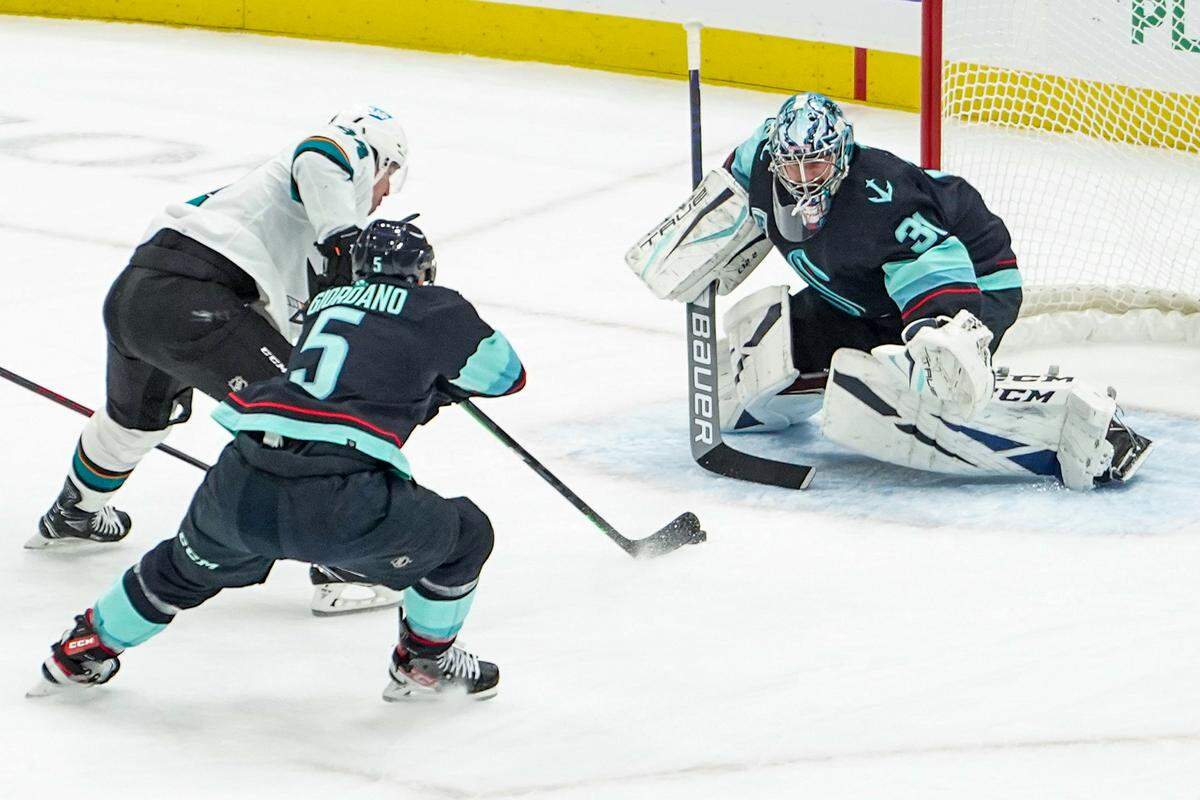 Seattle Kraken goalie Philipp Grubauer (31) reaches out to stop a goal shot attempt by the San Jose Sharks during the first period of an NHL hockey game at Climate Pledge Arena, Thursday Jan. 20, 2022, in Seattle.