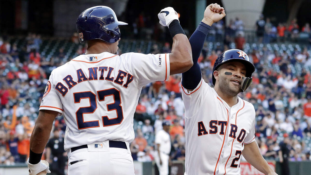 Houston Astros left fielder Michael Brantley (23) celebrate at the plate with Houston Astros second baseman Jose Altuve, right, after Altuve’s hit off the top of the left field wall and was ruled a home run after review during the first inning of a baseball game Wednesday, April 10, 2019, in Houston. (AP Photo/Michael Wyke)