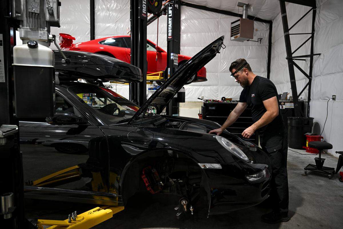 Co-owner Jacob Coen works on a Porsche at Spec German auto shop, Monday, Sept. 11, 2023, Gig Harbor, Wash.
