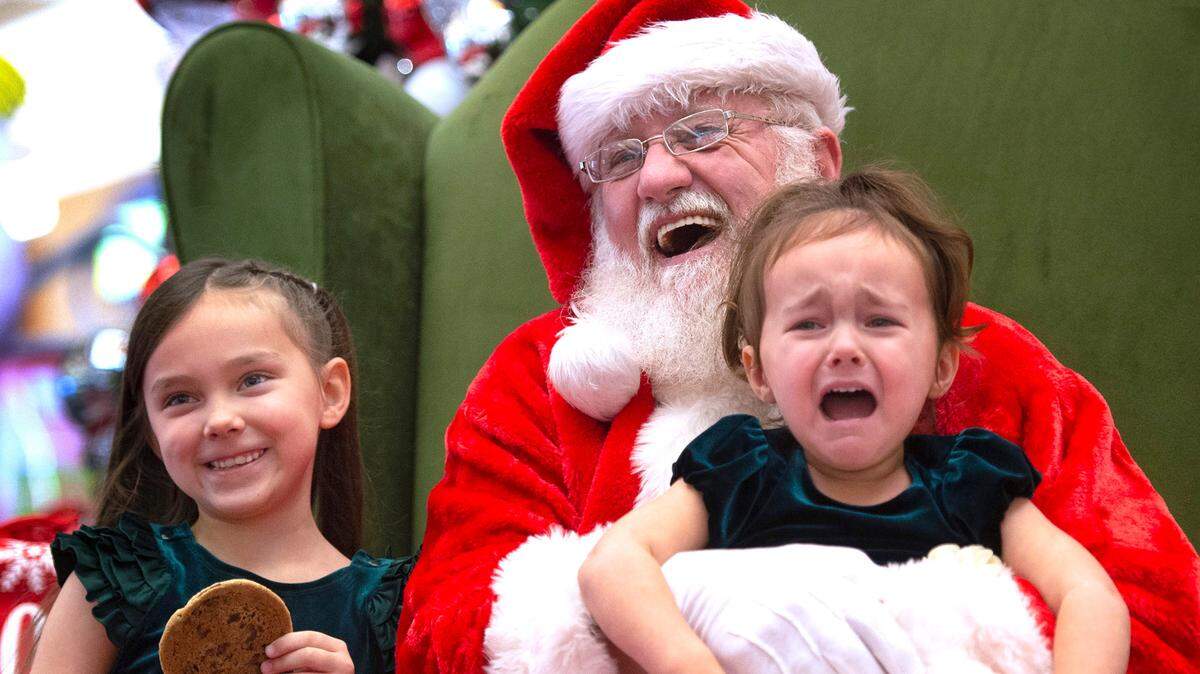Alana Bushong, 2, of Joint Base Lewis-McChord, expresses her displeasure as she poses for photos with Santa and her sister, LeeLynn Bushong, 6, at the South Hill Mall in Puyallup on Nov. 24, 2021. Santa is available for photos at both South Hill and Tacoma malls through Christmas Eve.