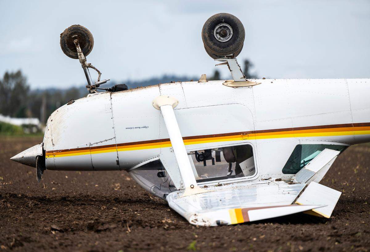 A two-seater plane crash landed upside down in a dirt field east of Pioneer Way and west of 66th avenue in Waller, Wash. on Oct. 26, 2022. The pilot was the only occupant of the plane and he was not injured.