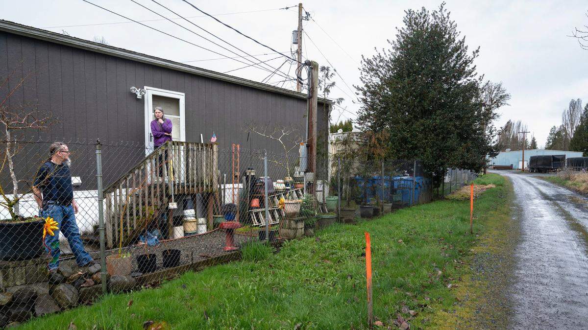 Daniel and Jamie Nowogroski’s Alpine Pioneer Mobile Home Park sits a chain-link fence away from the Pierce County surplus property proposed for sale along Pioneer Way near Puyallup, Washington, shown on Tuesday, March 12, 2024.