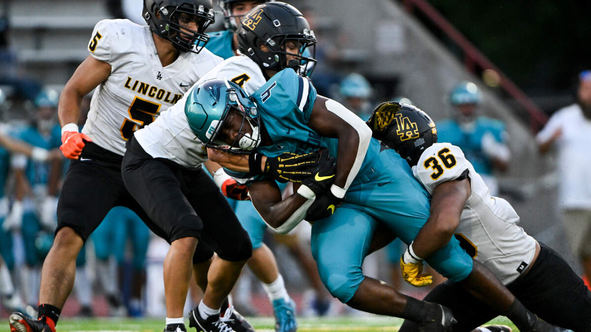 Auburn Riverside’s Jonathan Epperson (4) is brought down by a cadre of Lincoln defenders during the first half of the high school football game at Auburn Memorial Stadium, Friday, Sept. 1, 2023, Auburn, Wash.