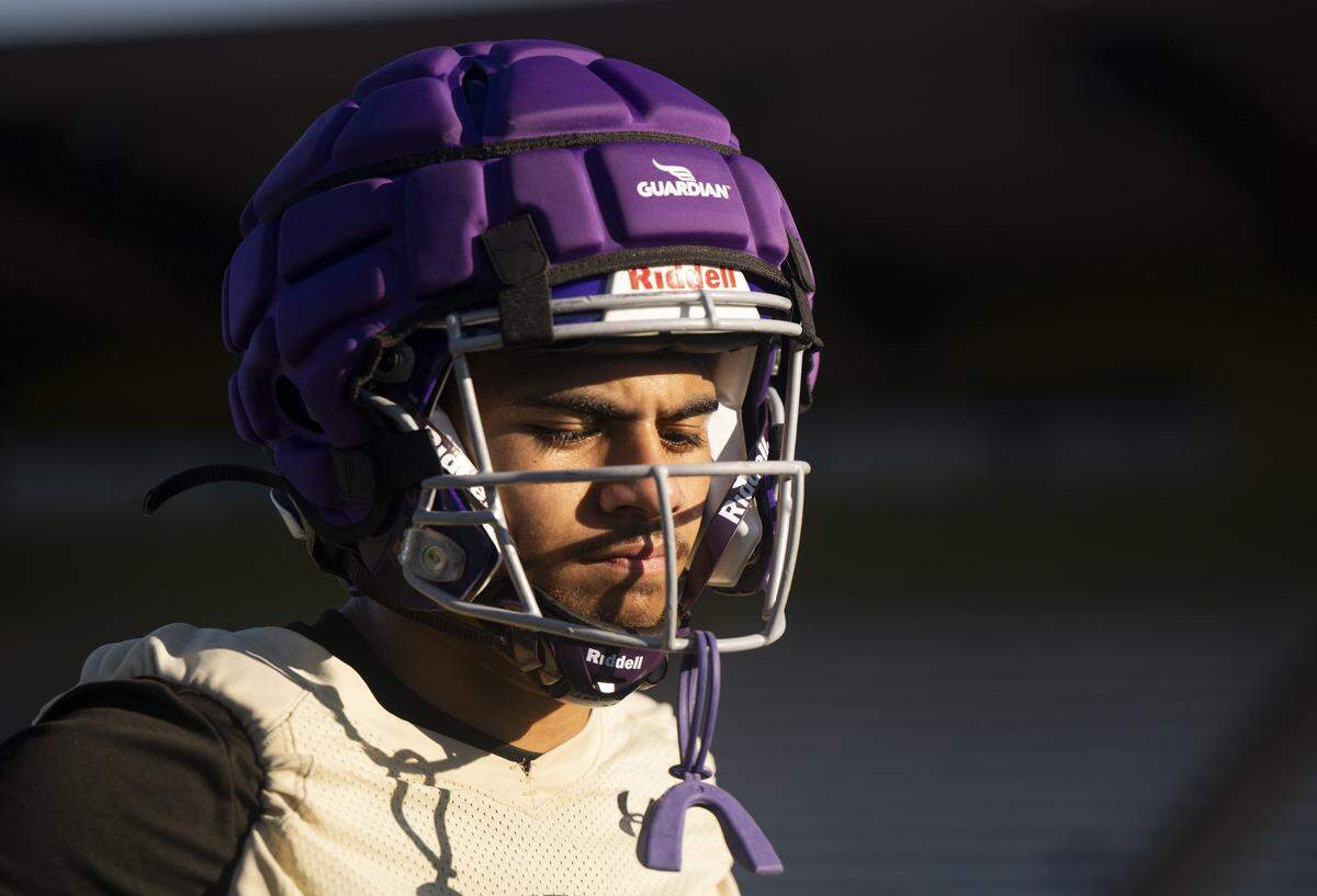 Puyallup linebacker Micahel Pulalasi listens in the huddle during a Puyallup High School football practice at Sparks Stadium on Thursday, Aug. 21, 2025, in Puyallup, Wash.