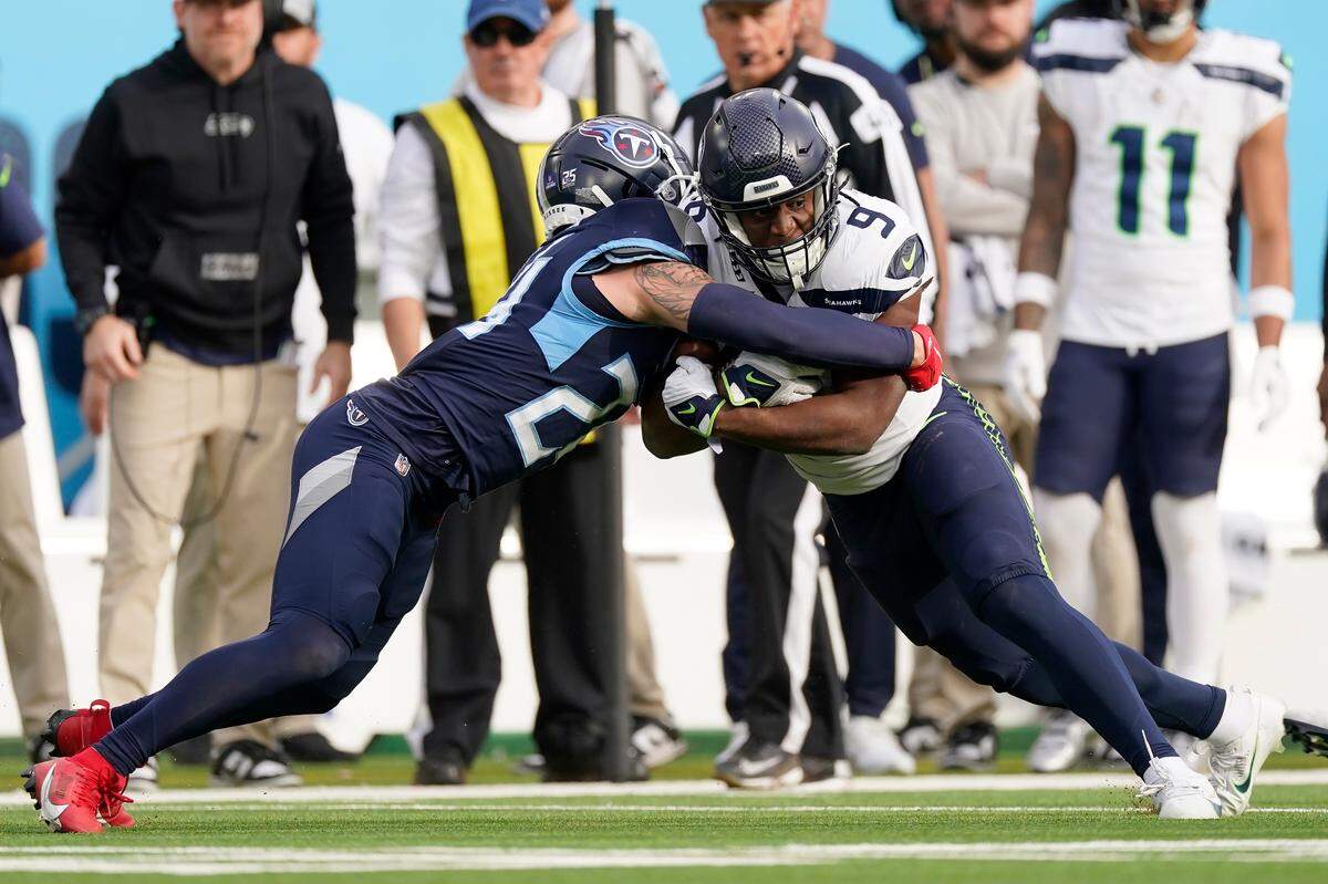 Tennessee Titans cornerback Elijah Molden, left, stops Seattle Seahawks running back Kenneth Walker III (9) during the second half of an NFL football game on Sunday, Dec. 24, 2023, in Nashville, Tenn. (AP Photo/George Walker IV)