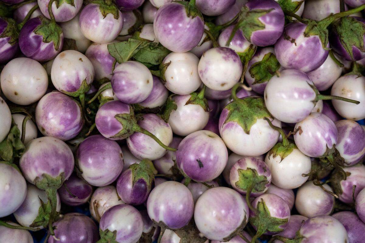A small produce section provides basics like onions and potatoes as well as East Asian necessities like bitter melon and Thai eggplant, shown here.