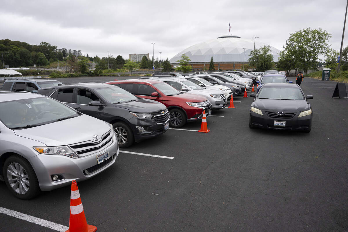 Cars line up in a parking lot of the Tacoma Dome for an Eloise’s Cooking Pot Food Bank emergency distribution on Wednesday, July 8, 2026, in Tacoma, Wash.