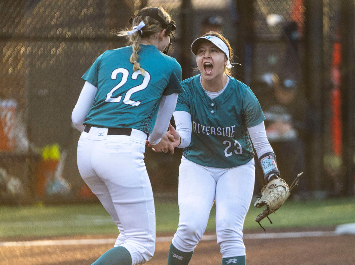 Auburn Riverside Kaylee Walker (23) high-fives Auburn Riverside pitcher Danica Butler (22) after Butler struck out a Kentwood player during a non-conference varsity softball game against Kentwood at Auburn Riverside High School in Auburn, Wash. on April 25, 2023. Kentwood defeated Auburn Riverside 3-0.