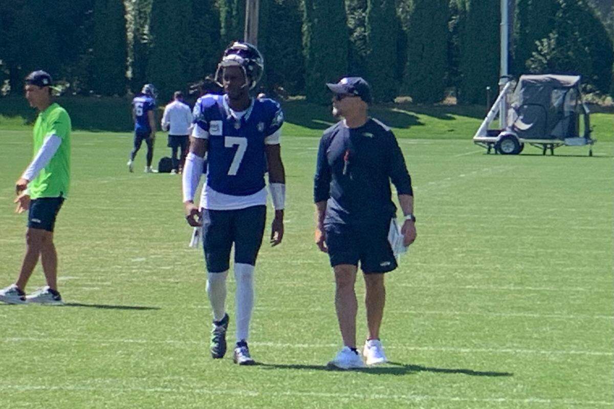 Geno Smith and offensive coordinator Ryan Grubb talk after the 11th practice of Seattle Seahawks training camp at the Virginia Mason Athletic Center in Renton Monday, Aug. 5, 2024. The Pro Bowl quarterback returned to practice after missing four of them with knee and hip issues.