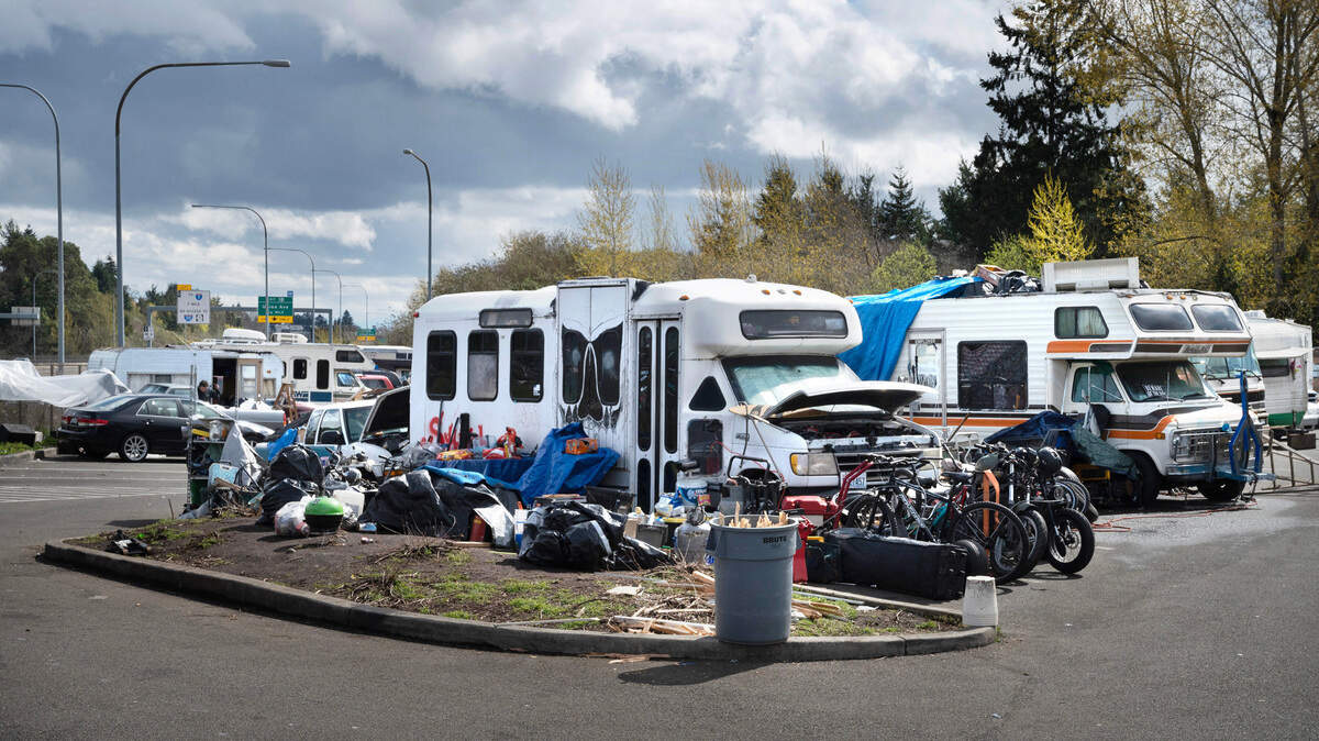 People living in motorhomes and travel trailers set up an encampment in the Pierce Transit Center Street Park & Ride lot on bordering Highway 16 in Tacoma. Photographed on Wednesday, April 19, 2023.