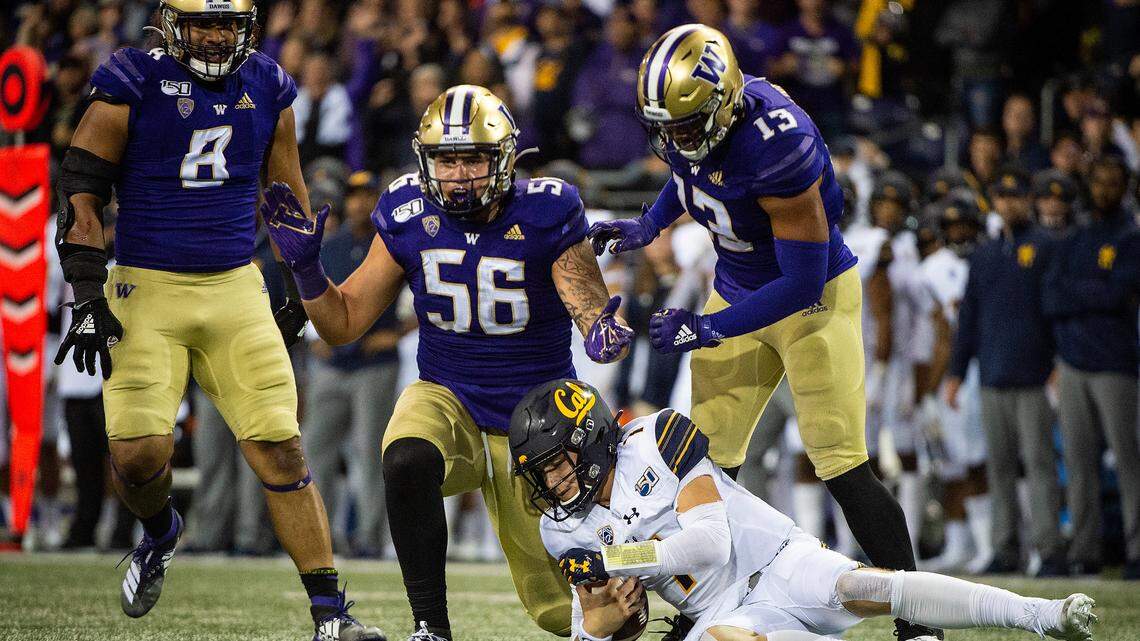 Washington Huskies linebacker Laiatu Latu (56) rects after sacking California Golden Bears quarterback Chase Garbers (7) during the second quarter. The Washington Huskies played the California Golden Bears in a NCAA football game at Husky Stadium in Seattle, Wash., on Saturday, Sept. 7, 2019.