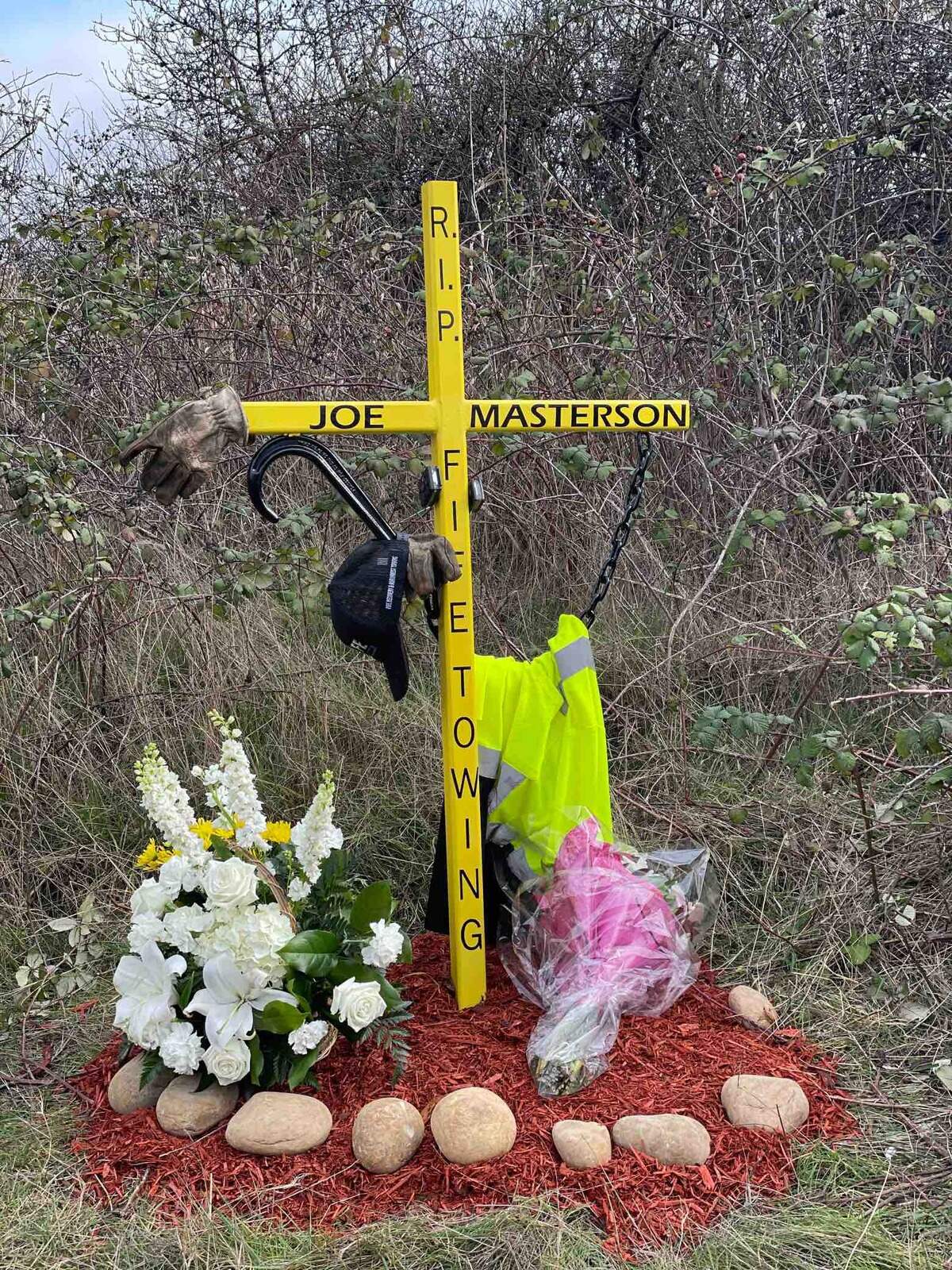 A cross adorned with a safety vest and surrounded by flowers was placed on the side of Interstate 5 where Masterson was struck and killed.&nbsp;
