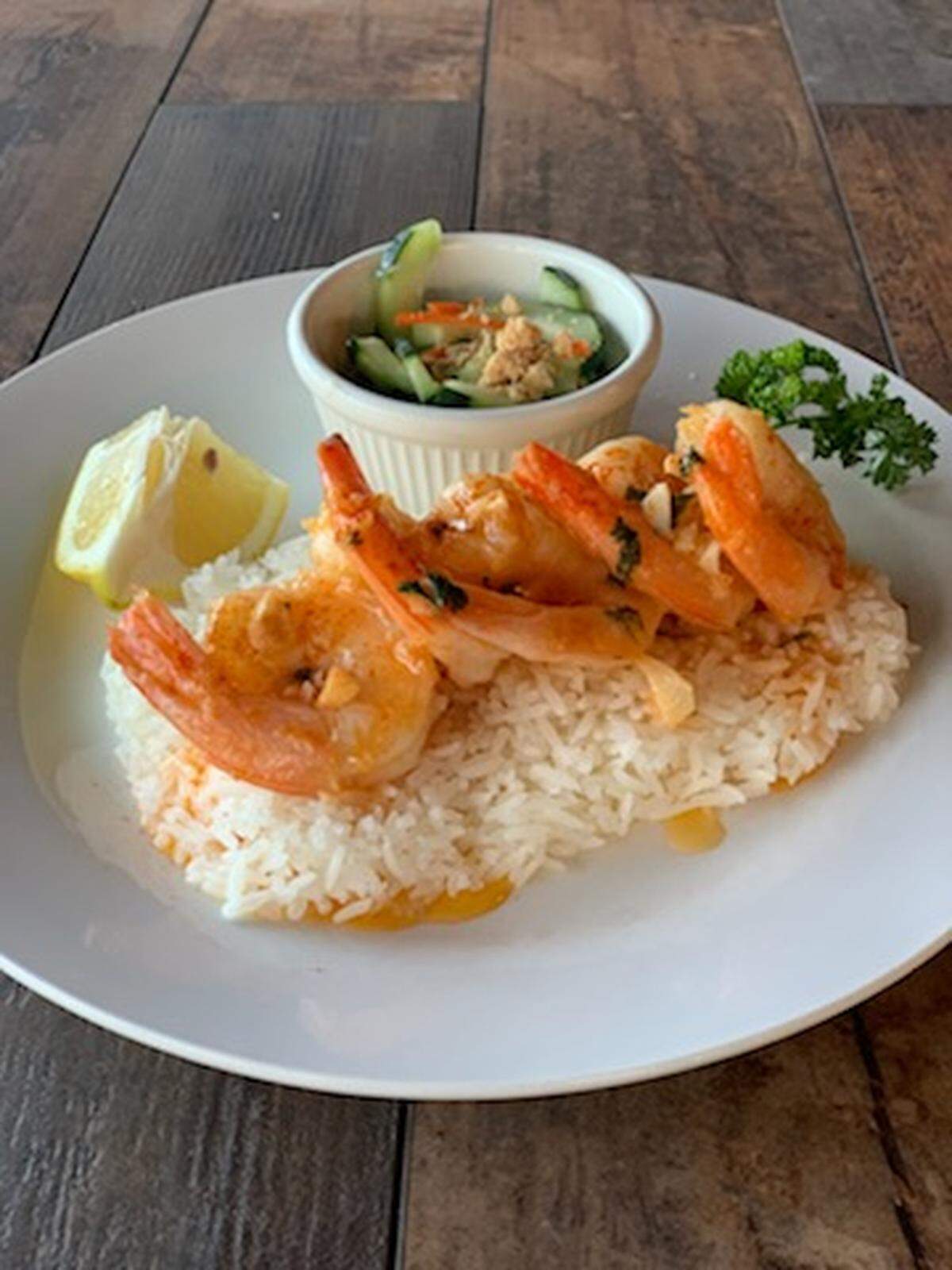Thirsty Hound Drinkery in University Place, Wash., embraces owner Malaty Lim’s Thai heritage with a trio of dishes, like this lemon butter shrimp over jasmine rice and served with a cucumber salad.