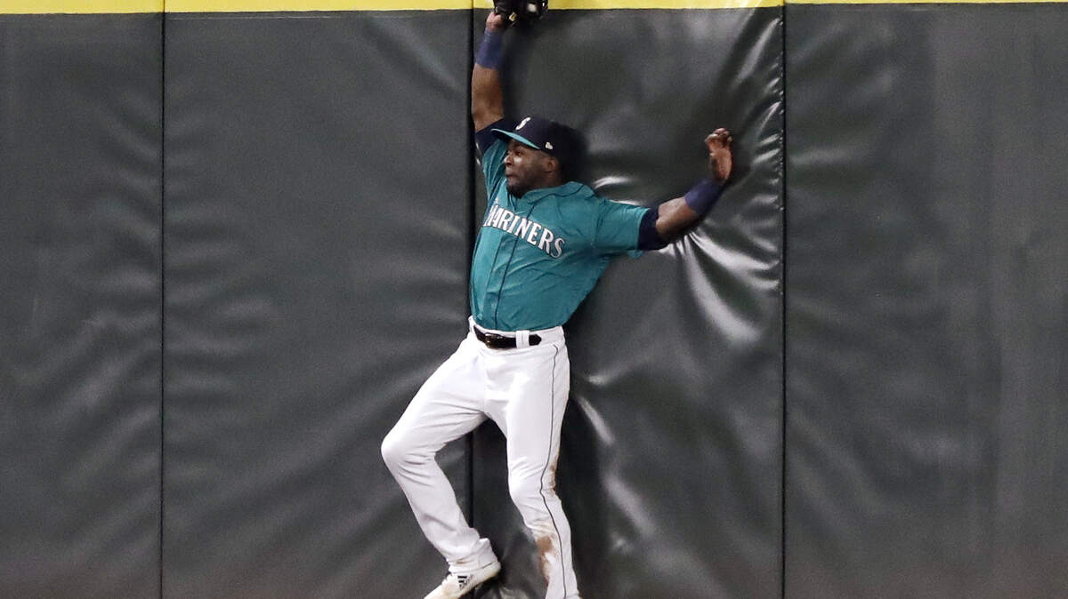 Seattle Mariners center fielder Guillermo Heredia bumps into the outfield wall after catching a deep fly ball from Texas Rangers’ Jurickson Profar during the fourth inning of a baseball game Friday, Sept. 28, 2018, in Seattle. (AP Photo/Elaine Thompson)