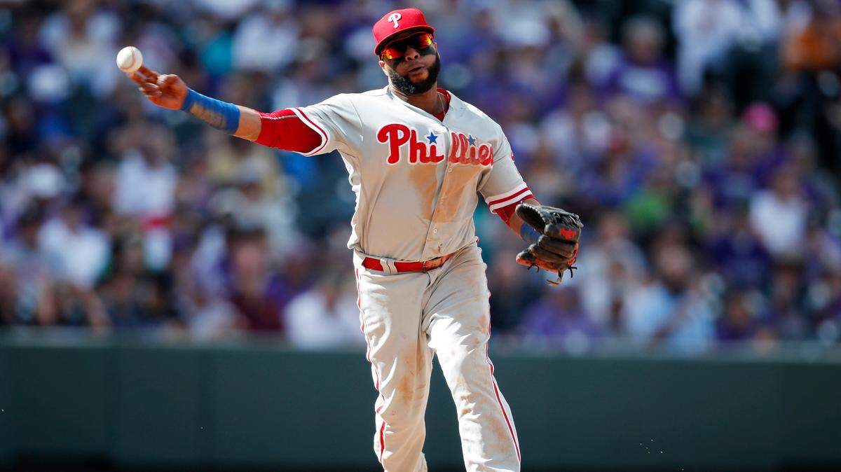 Philadelphia Phillies third baseman Carlos Santana throws to first base to put out Colorado Rockies’ DJ LeMahieu in the fifth inning of a baseball game Thursday, Sept. 27, 2018, in Denver. (AP Photo/David Zalubowski)