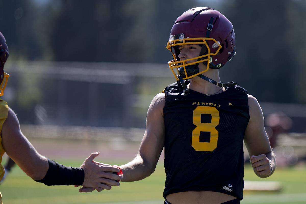 Capital wide receiver Chayton Hatch high fives quarterback Nolan Potts during a football practice at Capital High School on Friday, Aug. 22, 2025, in Olympia, Wash.