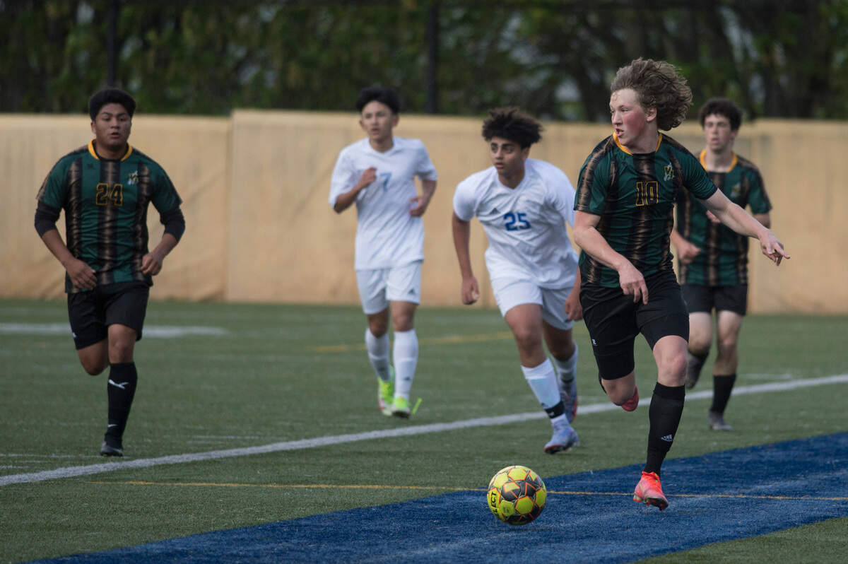Vashon Island High School midfielder Moses Trundle-Strachan brings the ball upfield in the first half of the Class 1A West Central District championship game on Thursday, May 12, 2022 at Stadium Bowl in Tacoma, Wash.