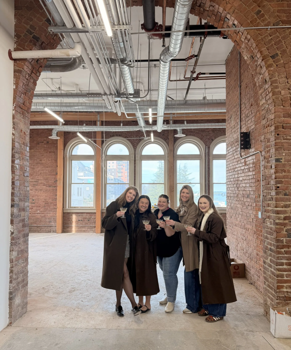 (From left) Ashley Whitney and Paddy Kay Lei, founders of SheWorks, celebrated their lease signing with friends at Old City Hall earlier this year. The business plans to open in the fourth-floor space this fall.
