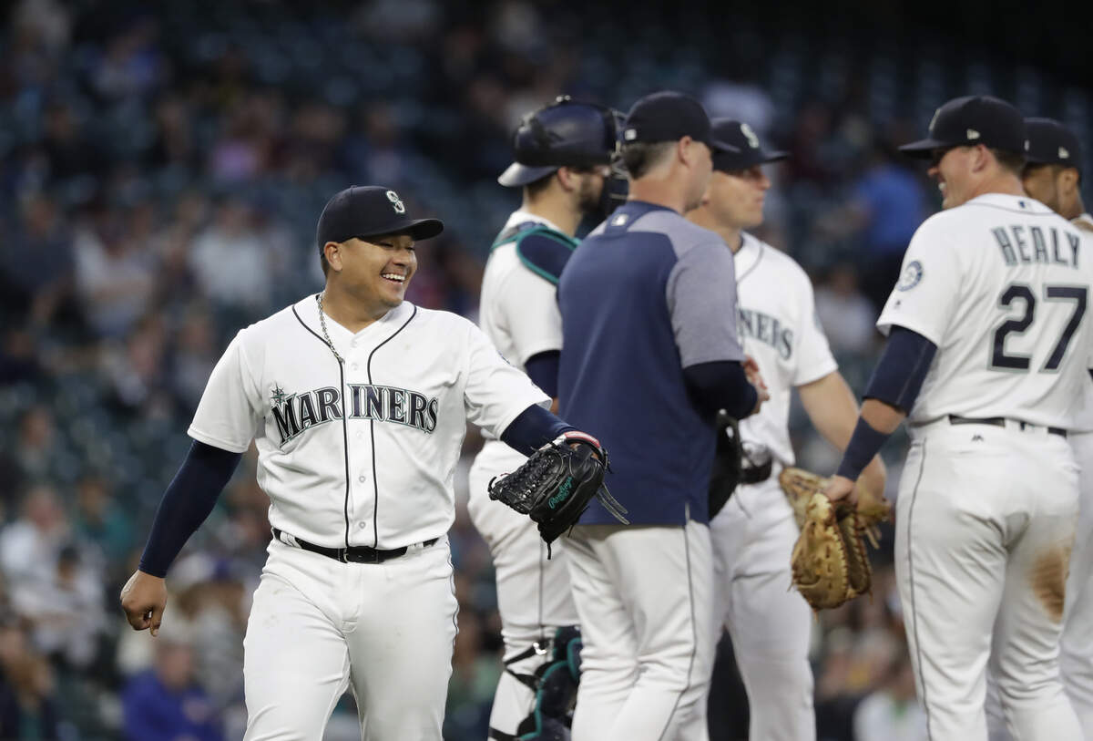 Seattle Mariners starting pitcher Erasmo Ramirez, left, smiles while being relieved against the Baltimore Orioles in the sixth inning of a baseball game Monday, Sept. 3, 2018, in Seattle. (AP Photo/Elaine Thompson)