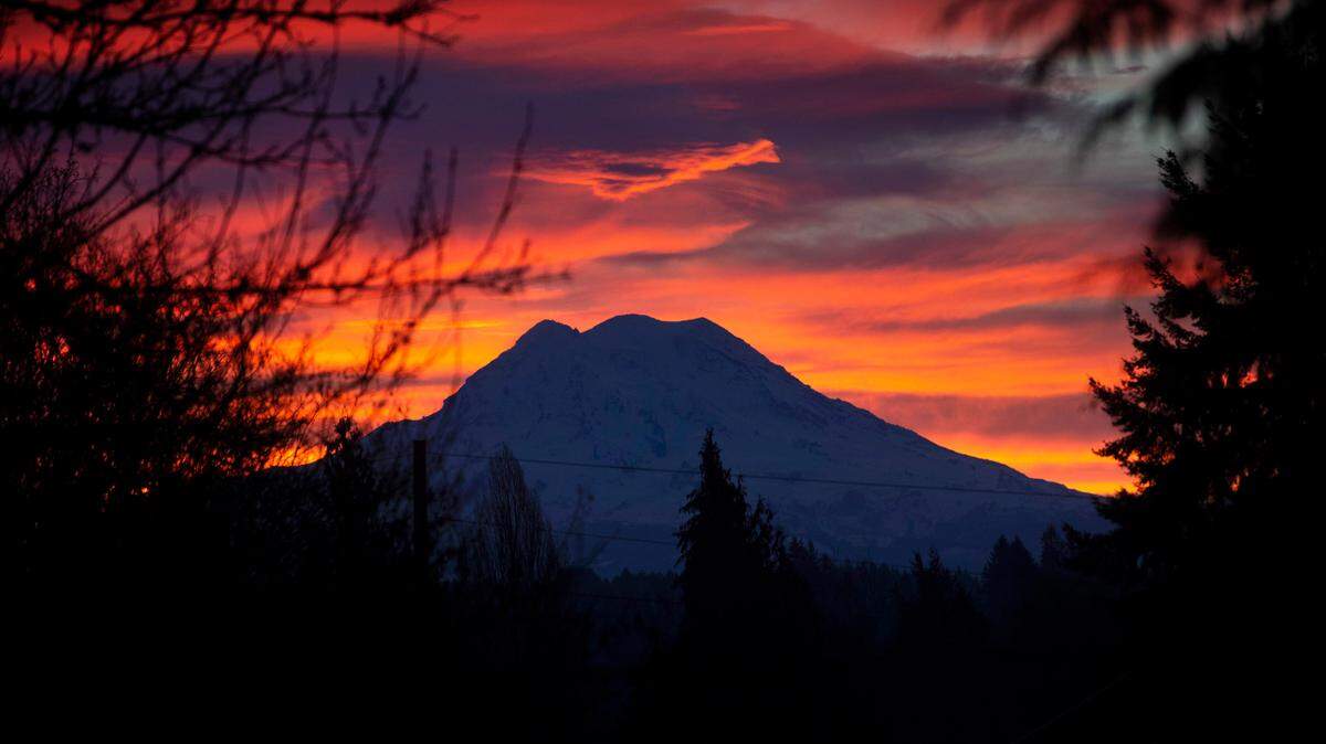 A colorful sunrise lights up the sky over Mount Rainier as seen from Tumwater, Washington, on Feb. 26, 2022.