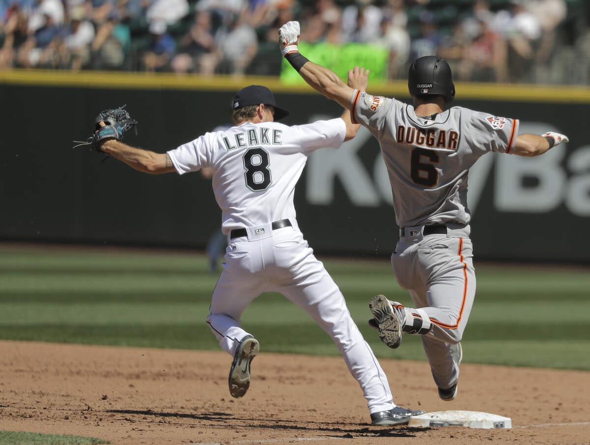 Seattle Mariners starting pitcher Mike Leake, left, forces out San Francisco Giants’ Steven Duggar at first base during the sixth inning of a baseball game, Wednesday, July 25, 2018, in Seattle. (AP Photo/Ted S. Warren)