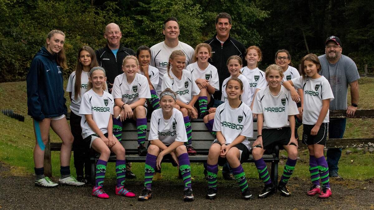 The “Kicking Snakes” soccer team, with Gig Harbor High School’s Alyssa Gray, left, who the team brought in to speak to the girls as a positive role model.