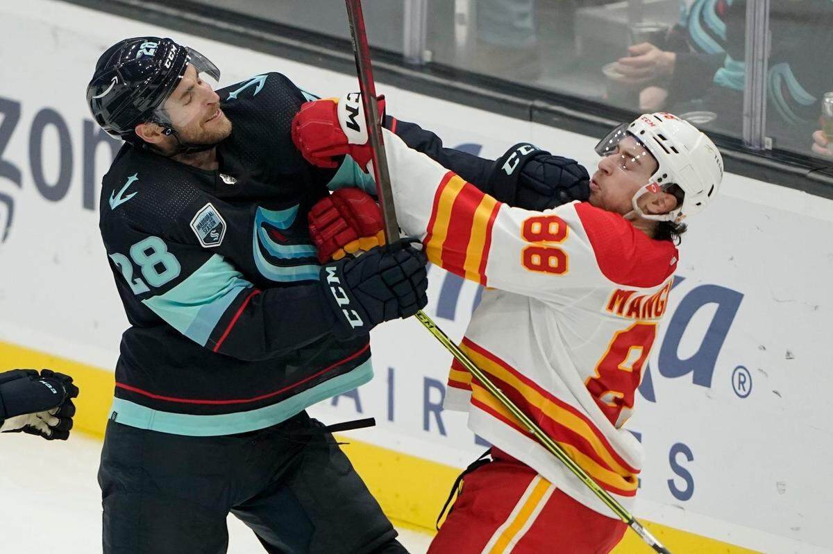 Seattle Kraken defenseman Carson Soucy (28) fights with Calgary Flames left wing Andrew Mangiapane (88) during the second period of an NHL hockey game Thursday, Dec. 30, 2021, in Seattle. (AP Photo/Ted S. Warren)