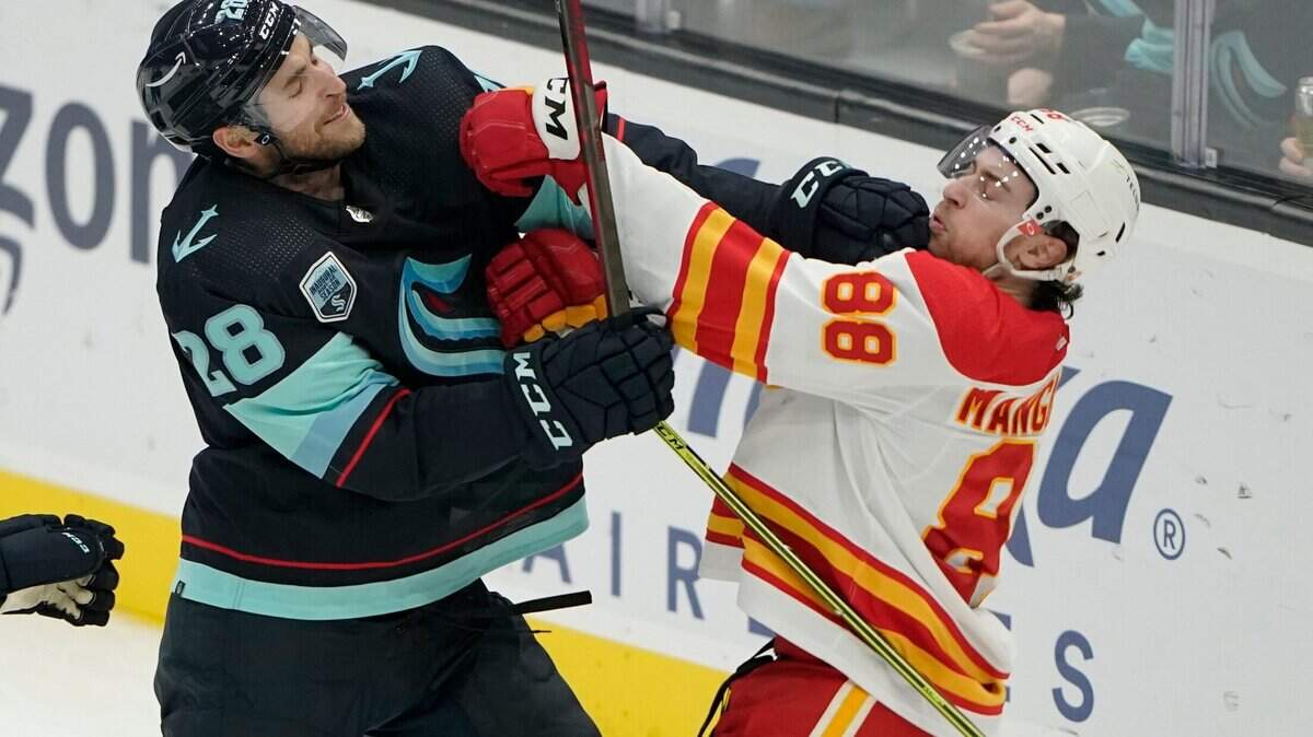 Seattle Kraken defenseman Carson Soucy (28) fights with Calgary Flames left wing Andrew Mangiapane (88) during the second period of an NHL hockey game Thursday, Dec. 30, 2021, in Seattle. (AP Photo/Ted S. Warren)