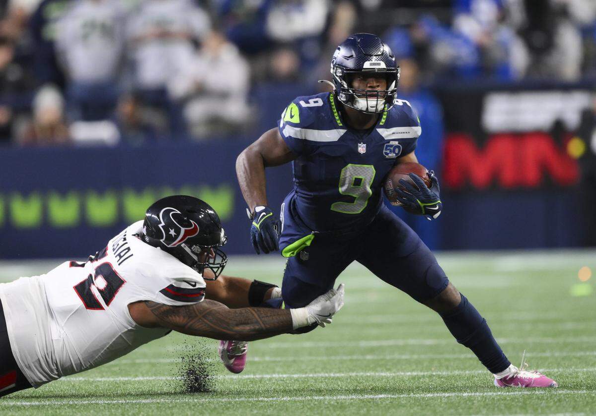 Seattle Seahawks running back Kenneth Walker III (9) slips the ankle tackle of Houston Texans defensive tackle Tommy Togiai (72) during the second quarter of the game at Lumen Field, on Monday, Oct. 20, 2025, in Seattle.