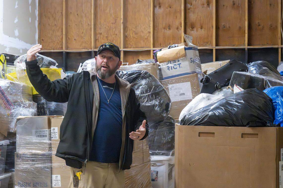 Brandon Simmons, founder and board chair of the Skoolie Foundation, talks through plans for the buildings purchased by the foundation on Monday, March 2, 2026, in Puyallup, Wash. Donations for Skoolie Thrift currently fill the space.