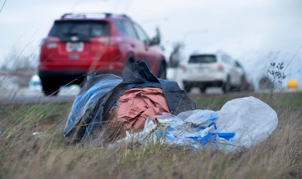 Trash lies along Interstate 5 through Tacoma on Feb. 17, 2021.