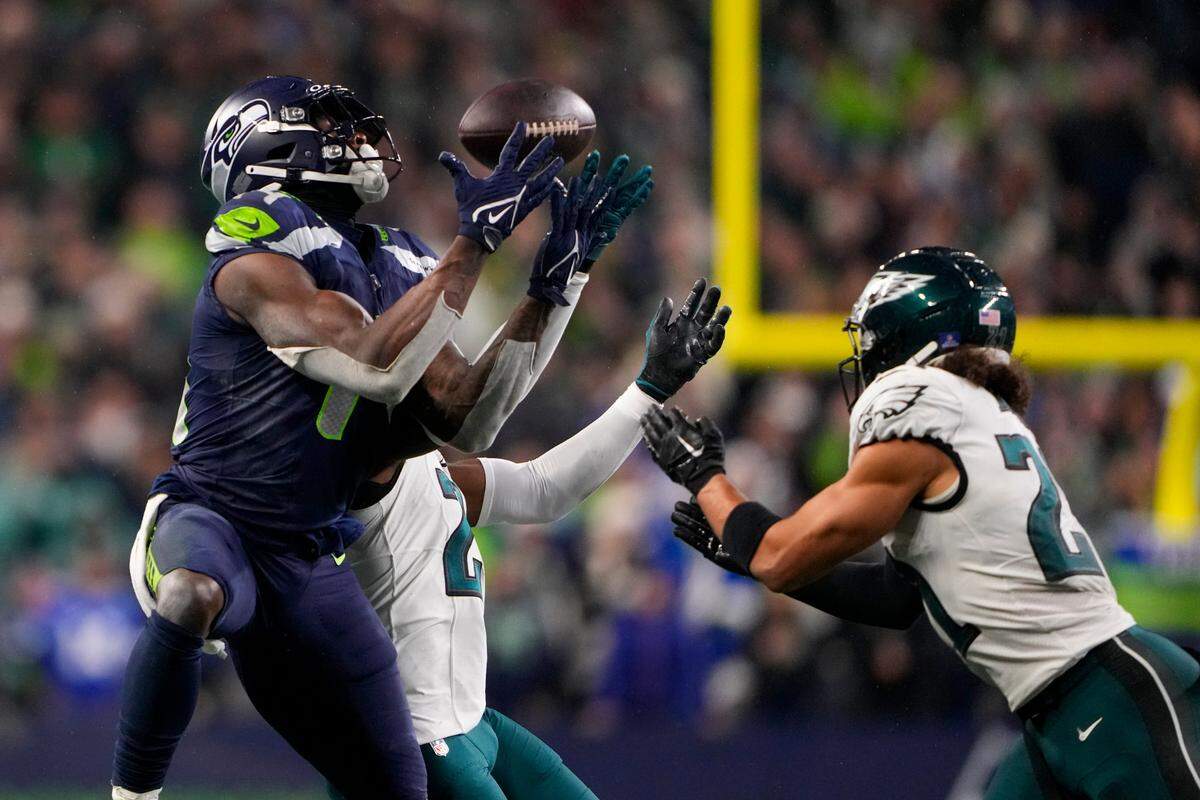 Seattle Seahawks wide receiver DK Metcalf, left, makes a catch in front of Philadelphia Eagles cornerback James Bradberry, center, and safety Sydney Brown (21) in the fourth quarter of an NFL football game, Monday, Dec. 18, 2023, in Seattle. The Seahawks won 20-17. (AP Photo/Lindsey Wasson)