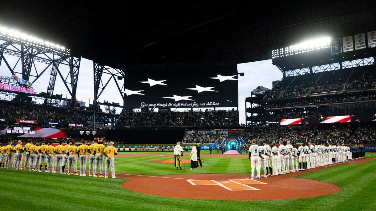 Seattle Mariners and Oakland Athletics observe the national anthem before the opening day game at T-Mobile Park in this March file photo.